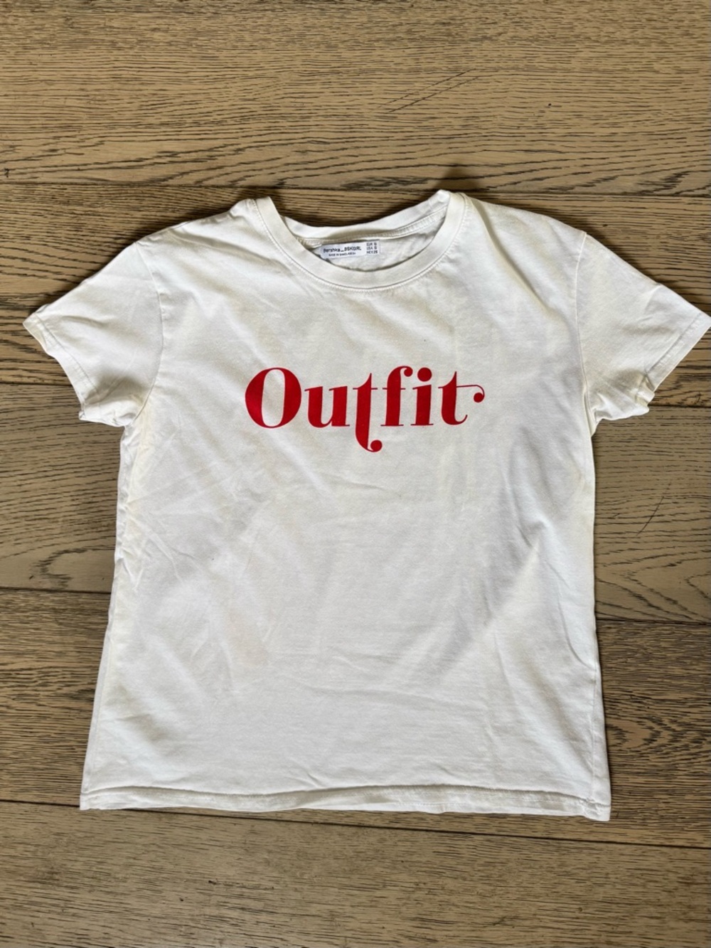 White Graphic Tee with “Outfit” in Red